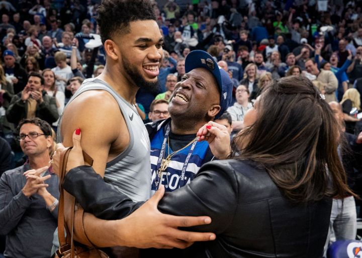 Timberwolves player Karl Anthony Towns hugs his parents after a game.
