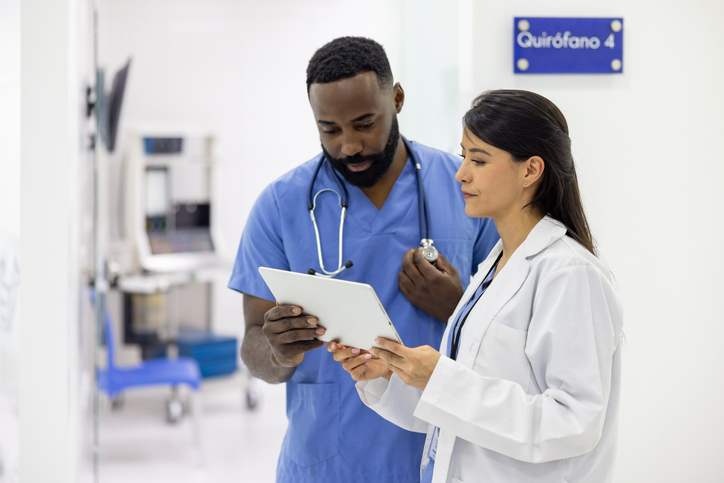 Team of doctors at the hospital reading test results on a tablet